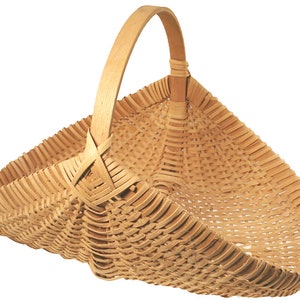 May include: A woven basket with a natural wood finish and a single handle. The basket is made of thin strips of wood that are woven together to create a sturdy and durable container.