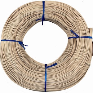 May include: A roll of natural-colored wicker rattan, approximately 1/4 inch thick, tied with blue ribbon. The rattan is wound into a circle and is ready for weaving.