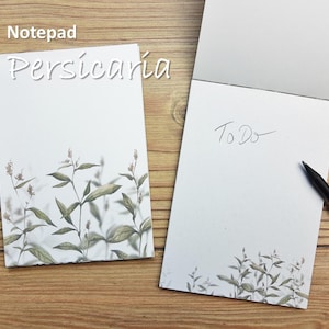 Könnte beinhalten: Ein Notizblock mit einem floralen Design und dem Text "Persicaria" auf dem vorderen Umschlag. Die Rückseite des Notizblocks trägt den Text "To Do".