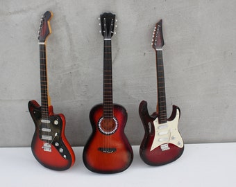 Tres guitarras en miniatura, réplicas de guitarras eléctricas y acústicas originales de colección