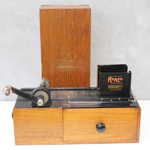 Máquina de direcciones antigua, dispositivo postal de mediados de siglo, diseño industrial de la era media, maquinaria de oficina del período central, aparato de correo