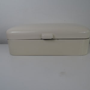 May include: A white enamel bread box with a hinged lid and a small handle on the top.