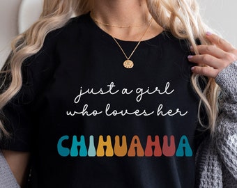 May include: A black t-shirt with the text "just a girl who loves her chihuahua" in white script. The word "chihuahua" is in rainbow colored letters.