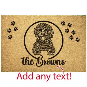 May include: A brown doormat with a black and white illustration of a dog inside a circle. The text "the Browns" is below the circle. There are paw prints on the doormat. The text "Add any text!" is below the doormat.