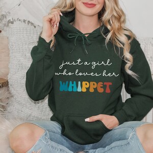 Może przedstawiać: Zielona bluza z kapturem z napisem "just a girl who loves her WHIPPET" w kolorze białym i tęczowym.