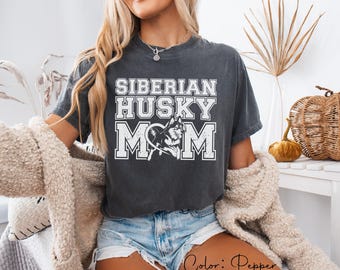 Könnte beinhalten: Dunkelgraues T-Shirt mit dem Text "SIBERIAN HUSKY MOM" in weißen Blockbuchstaben. Das Design beinhaltet eine Grafik eines Siberian Huskys. Das Shirt hat die Farbe Pfeffer.