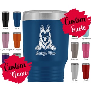 Puede incluir: Un vaso térmico de acero inoxidable azul con una silueta blanca de pastor alemán y el texto "Buddy's Mom". El vaso está rodeado de vasos más pequeños de varios colores, incluyendo negro, azul, morado claro, naranja, verde, azul claro, peltre, rosa, blanco y rojo.