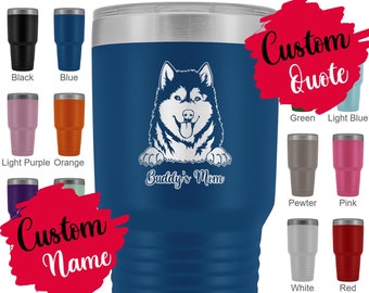 May include: A blue stainless steel tumbler with a white Alaskan Malamute dog peeking over the top. The tumbler has the text "Buddy's Mom" on it. The image shows a variety of color options for the tumbler.