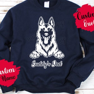 Puede incluir: Sudadera azul marino con un gráfico de perro pastor alemán blanco y el texto "Buddy's Dad". La sudadera tiene un círculo rojo con el texto "Custom Name" y un círculo rojo con el texto "Custom Quote".
