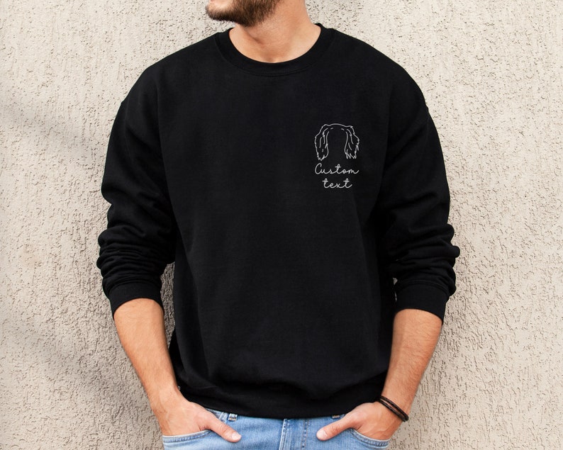 May include: Black sweatshirt with a white outline of a dog's head and the text "Custom text" on the front.