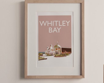 May include: A framed print with a pink background and white text that reads "WHITLEY BAY". The print features a stylized illustration of a building with a dome roof and a flag.