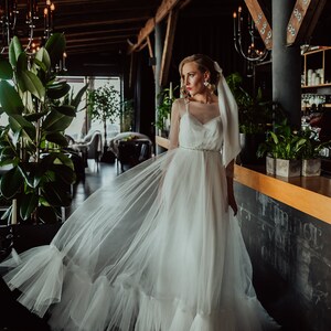 Vestido de novia bohemio de tul marfil con espalda abierta y dobladillo con volantes/Romántico vestido de novia de tul sin espalda con mangas largas y cola corte imagen 4