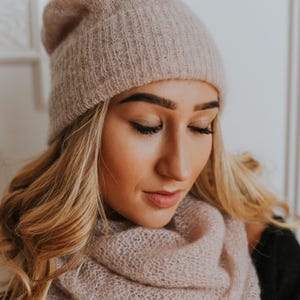 Peut inclure: Un bonnet et une &eacute;charpe assortis en tricot rose p&acirc;le et doux. Le bonnet est ample et pr&eacute;sente une texture c&ocirc;tel&eacute;e. L'&eacute;charpe est longue et s'enroule autour du cou.