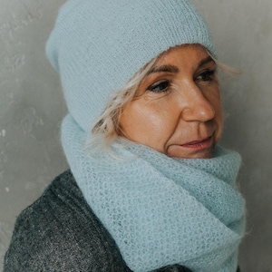 Peut inclure: Un bonnet et une &eacute;charpe assortis en tricot bleu clair. Le bonnet est de style beanie et l'&eacute;charpe est une &eacute;charpe &agrave; col.