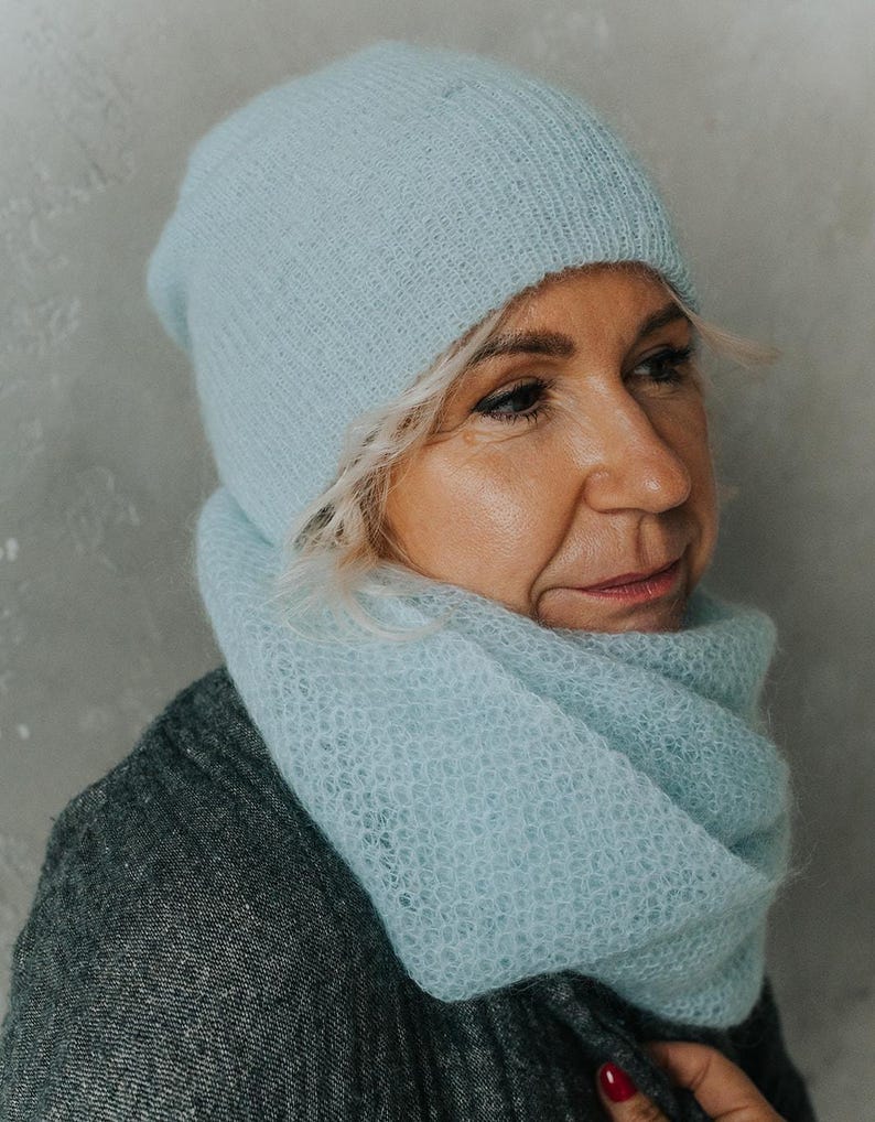 Peut inclure: Un bonnet et une &eacute;charpe assortis en tricot bleu clair. Le bonnet est de style beanie et l'&eacute;charpe est une &eacute;charpe &agrave; col.