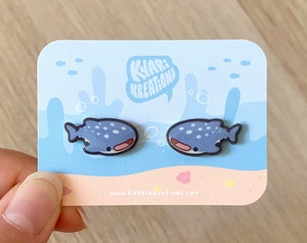 May include: A pair of blue whale shark earrings on a white card with the text "Kyar: Kreations" and a website address. The earrings are on a white background with a blue ocean scene.