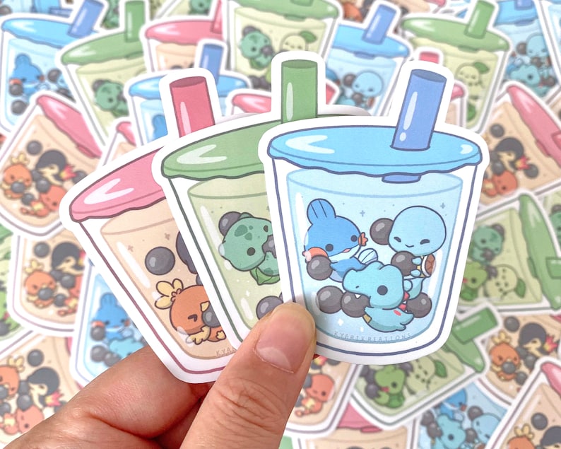 May include: Three bubble tea stickers with different colored lids and straws. The bubble tea cups are filled with boba pearls and cartoon characters. The stickers are on a white background.