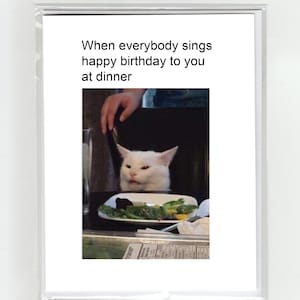 Gatto cattivo arrabbiato confuso al tavolo da pranzo Meme Biglietto di buon compleanno Virale Scherzo divertente Pippo eccentrico giocoso