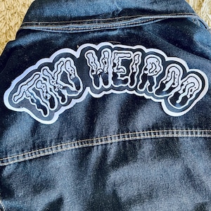 May include: A black denim jacket with a white and black "The Weirdos" patch sewn on the back.