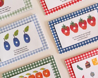 Può includere: Una collezione di sei cartoline rettangolari con illustrazioni di frutta e alimenti con fori perforati. Ogni cartolina è montata su un bordo di carta con motivo a quadretti vichy in vari colori, tra cui rosso, blu e verde.
