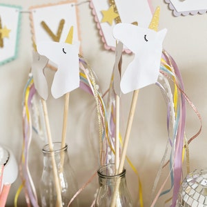 Pu&ograve; includere: Due bacchette a forma di testa di unicorno bianca con corna dorate e nastri arcobaleno in bottiglie di vetro. Le teste di unicorno sono fatte di carta e hanno occhi e ciglia neri. Le bacchette sono fatte di legno e sono lunghe circa 30 cm. I nastri sono fatti di nastro colorato e sono lunghi circa 45 cm.