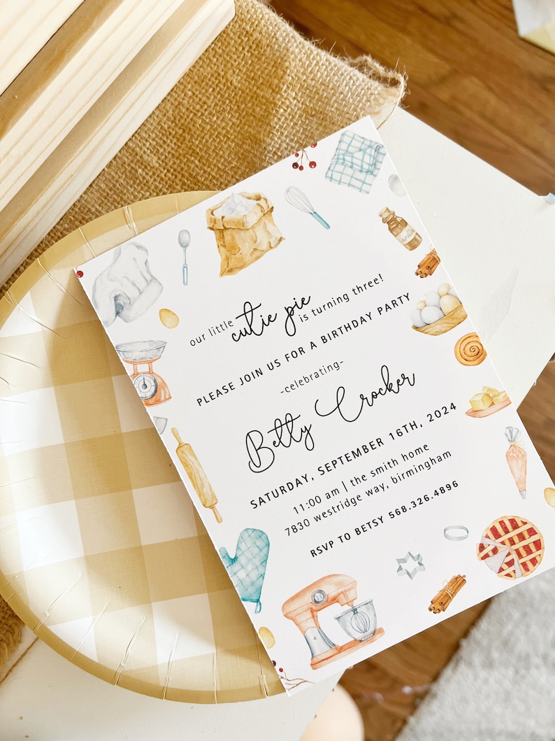 May include: A white invitation card with a watercolor illustration of baking supplies, including a rolling pin, a mixing bowl, a whisk, a bag of flour, and a pie. The text on the card reads "our little cutie pie is turning three! Please join us for a birthday party -celebrating- Betty Crocker Saturday, September 16th, 2024 11:00 am | the smith home 7830 westridge way, birmingham RSVP to Betsy 568.326.4896".