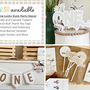 May include: A set of party decorations for a first birthday with a duck theme. The decorations include a cake topper, cupcake toppers, thank you tags, invitations, banners, and paper straws. The decorations are in a rustic style with a gingham pattern and duck illustrations.