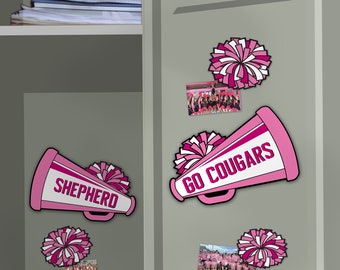 Peut inclure: Aimants sur le thème des cheerleaders roses et blancs sur un casier gris. Les aimants comprennent des mégaphones avec les mots "SHEPHERD" et "GO COUGARS", des pompons et des photos d'équipe. Le thème général est l'esprit d'école et les cheerleaders.
