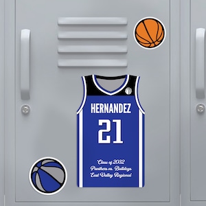 Puede incluir: Una camiseta de baloncesto azul y negra con el nombre "HERNANDEZ" y el número "21" en blanco. También son visibles dos pegatinas de baloncesto y el texto "Class of 2032 Panthers vs. Bulldogs East Valley Regional".