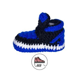 May include: Blue and black crocheted baby booties shaped like sneakers. The booties have a white trim around the sole.