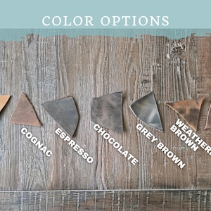 May include: Image showcasing leather color options: Tan, Cognac, Espresso, Chocolate, Grey Brown, Weathered Brown, and Warm Brown. The text "COLOR OPTIONS" is at the top. The leather swatches are arranged on a wooden surface.