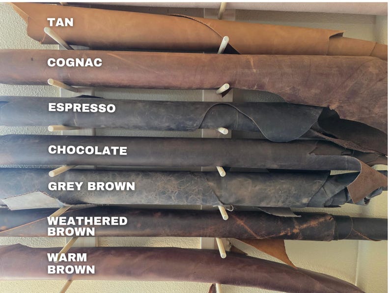May include: A selection of leather hides in various shades of brown, including tan, cognac, espresso, chocolate, grey brown, weathered brown, and warm brown. Each hide is labeled with its color name.
