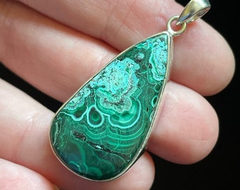 May include: A teardrop-shaped pendant with a green malachite stone set in sterling silver.