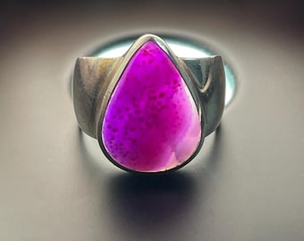 May include: A silver ring with a teardrop-shaped purple agate gemstone.
