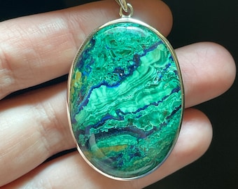 May include: Oval shaped pendant with a green and blue malachite stone set in sterling silver.