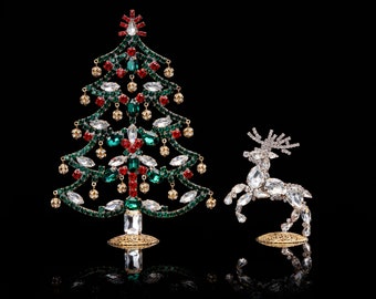 May include: A jeweled Christmas tree ornament with green and red crystals and a jeweled reindeer ornament with clear crystals.