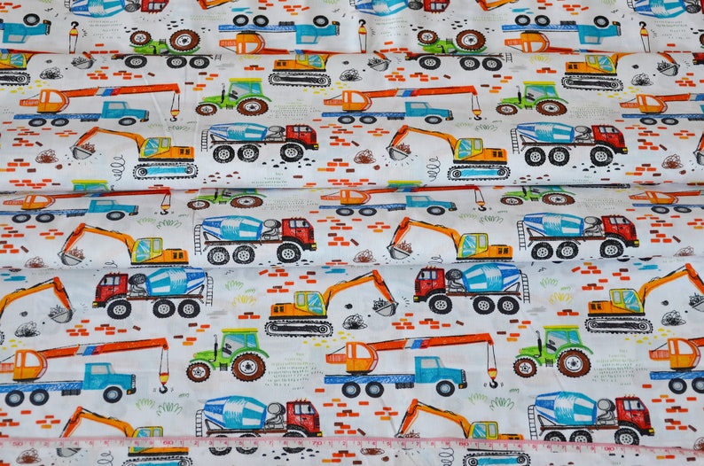 May include: White fabric with a repeating pattern of construction vehicles. The vehicles are drawn in a cartoon style and include cement mixers, excavators, and tractors. The fabric is perfect for quilting, crafts, and other sewing projects.