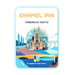 Pu&ograve; includere: Spilla smaltata raffigurante il Castello di Cenerentola in blu, bianco e oro. La spilla include una scarpetta di cristallo ed &egrave; ambientata su uno sfondo di cielo blu e paesaggio. Le parole "ENAMEL PIN" e "CINDERELLA CASTLE" sono stampate sulla carta.