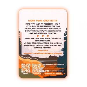 May include: A rectangular card with rounded corners, featuring text in orange and white. The card promotes creativity and accessories for jackets and bags. It also mentions patterns and kits for embroidery, cross-stitch, beading, and diamond painting. The card is designed in Ukraine.