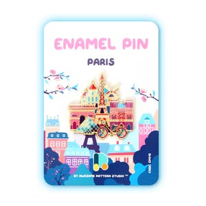 Könnte beinhalten: Ein farbenfroher Emaille-Pin mit ikonischen Pariser Wahrzeichen, darunter der Eiffelturm und der Arc de Triomphe. Der Pin befindet sich vor einer Stadtkulisse und dem Text "ENAMEL PIN PARIS". Der Pin befindet sich auf einer weißen Karte mit dem Text "BY AWESOME PATTERN STUDIO TM" und "CODE: EP016".