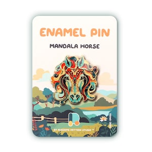 Puede incluir: Un pin de esmalte con un diseño de caballo mandala colorido. El pin tiene un contorno dorado y se presenta sobre una tarjeta con el texto "ENAMEL PIN MANDALA HORSE". El fondo muestra un paisaje con árboles, colinas y una valla.