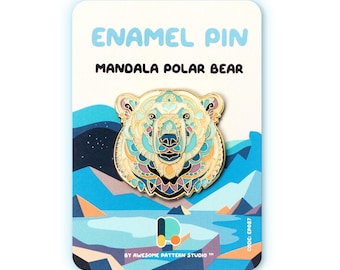 May include: An enamel pin with a mandala polar bear design. The pin has a gold outline and a colourful interior of blues, teals, and purples. The pin is on a card with the text "ENAMEL PIN MANDALA POLAR BEAR".