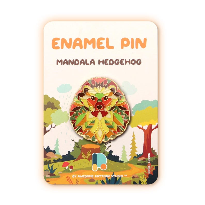 Puede incluir: Un pin de esmalte con un dise&ntilde;o de erizo mandala colorido. El pin se presenta sobre una tarjeta con el texto "ENAMEL PIN MANDALA HEDGEHOG" y una escena de bosque. El pin tiene una paleta de colores vibrantes de rojo, amarillo, verde y naranja.