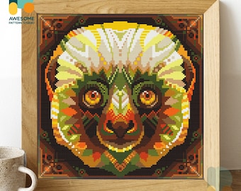 May include: A colorful pixel art image of a lemur's face. The lemur's fur is a mix of green, yellow, orange, and brown. The lemur has large, round, yellow eyes. The image is framed in a brown wooden frame.