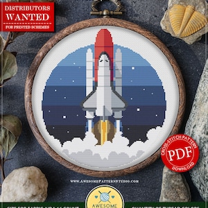 Può includere: Modello di punto croce contato per il download immediato, che presenta uno shuttle spaziale che decolla nello spazio. Il modello è in una cornice di legno circolare, con uno sfondo blu e stelle bianche. Il modello è etichettato come "C509 Space Rocket" ed è disponibile per il download in PDF. Il modello misura 19,05 x 21,27 cm e utilizza 17 colori di filo DMC.
