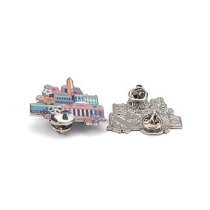 May include: A silver-toned metal enamel pin featuring a panda, cherry blossoms, and architectural landmarks including a tall obelisk and a domed building. The reverse side shows the metal backing with two pin posts and butterfly clutches.
