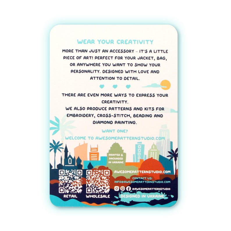 May include: A white card with text that reads "WEAR YOUR CREATIVITY" and "WELCOME TO AWESOMEPATTERNSTUDIO.COM". The card features a colorful skyline illustration and QR codes for retail and wholesale.