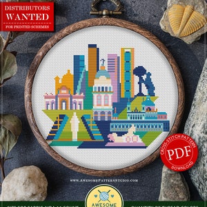 May include: A cross stitch pattern for a colorful cityscape of Madrid, Spain. The pattern is in a wooden embroidery hoop and is labeled "Nº C155_Madrid". The pattern is available as a PDF download. The pattern is 105 stitches wide by 86 stitches high and requires 18 colors of DMC thread.