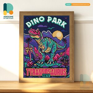 Puede incluir: Imagen enmarcada de punto de cruz con temática de dinosaurios. La obra de arte incluye un Tyrannosaurus Rex, palmeras y las palabras "Dino Park" y "Tyrannosaurus Rex". La paleta de colores incluye tonos de azul, rosa y amarillo.