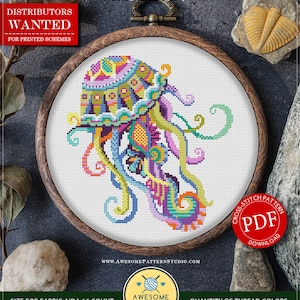Puede incluir: Un patrón de punto de cruz colorido de una medusa mandala, enmarcado en un aro de madera. El patrón está disponible para descargar en PDF. El patrón tiene 99 puntos de ancho por 105 puntos de alto y utiliza 16 colores de hilo DMC.